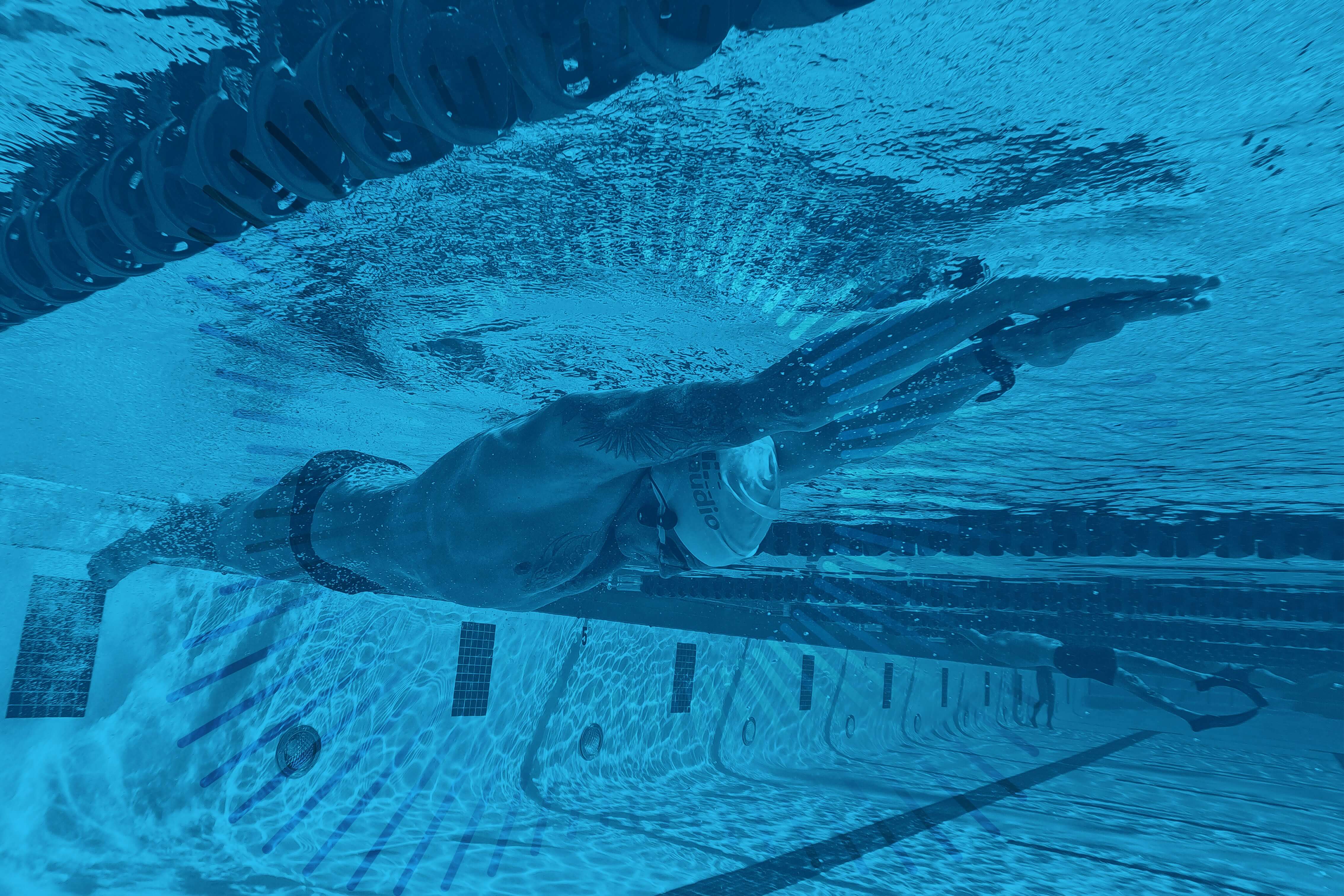 image of a swimmer using waterproof bone conduction headphones during practice located on the h2o audio waterproof headphones homepage